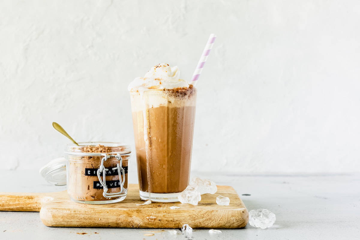 Ein Glas mit Eiskaffee, daneben eins mit Eiskaffeepulver